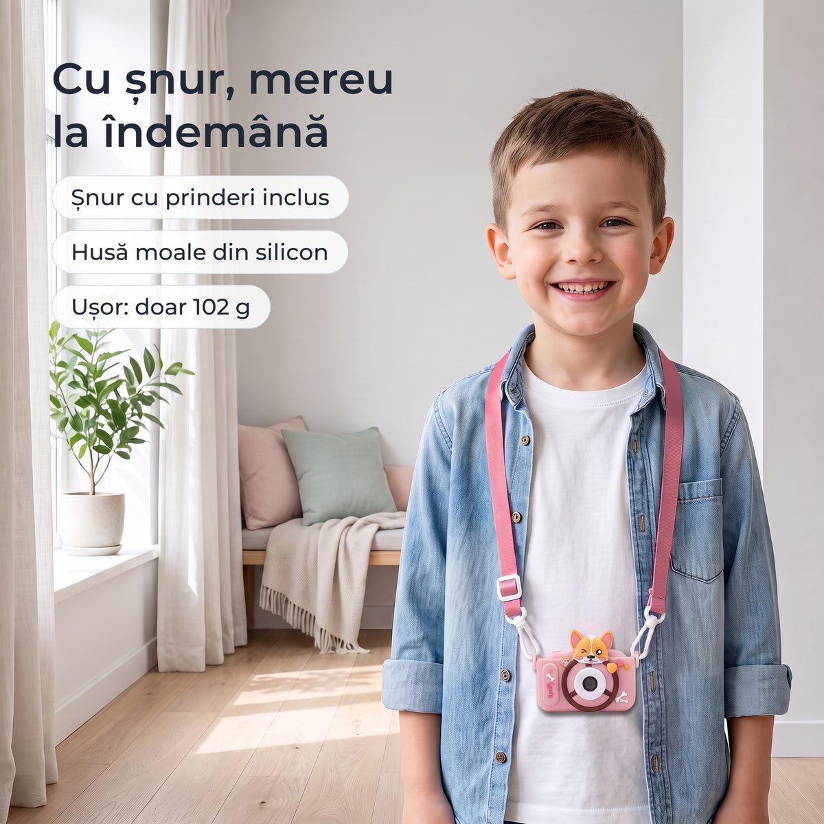 Băiat cu aparatul foto roz la gât, pe șnurul inclus, cu husă moale din silicon 