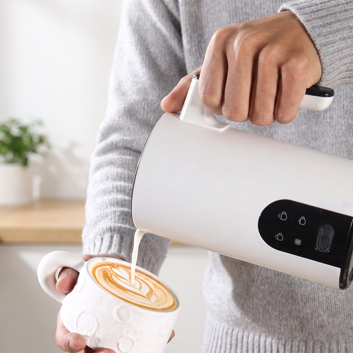 Lapte spumat turnat din spumătorul alb peste un cappuccino 